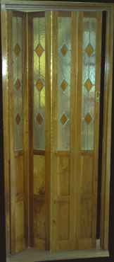 Puerta plegadiza en cedro con diseño vitraux

